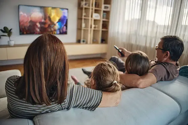 Multi-generation family enjoying streaming content loaded through Xtream Codes on a smart TV