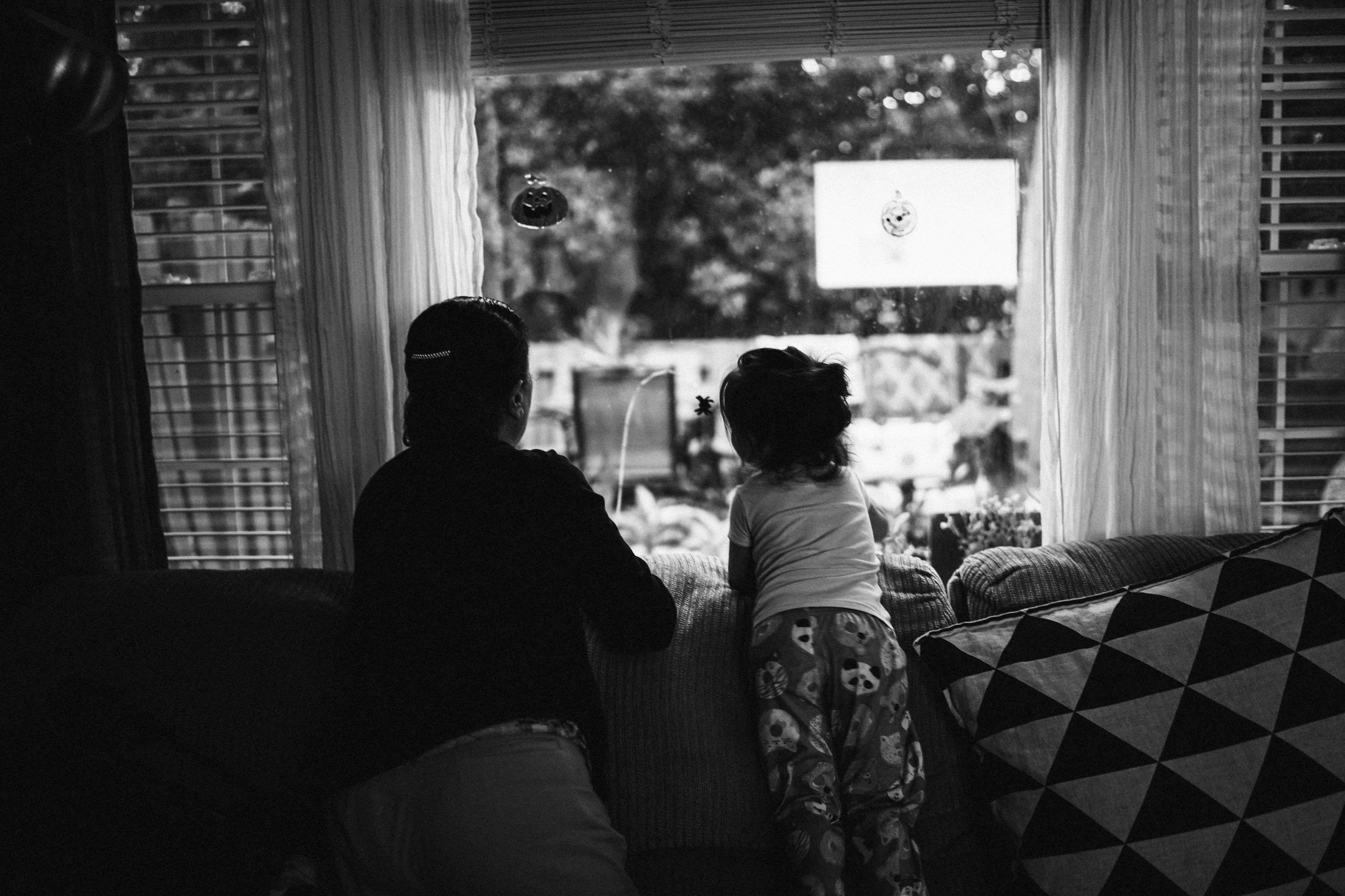Family relaxing and watching series on TV with a media player app showing episode navigation